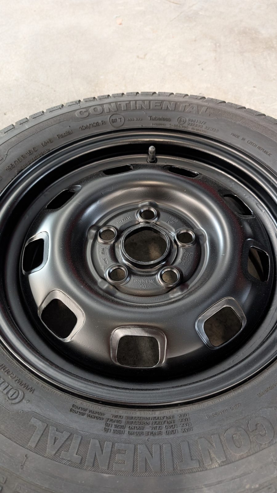 The same steel wheel refinished to a clean, factory-fresh look